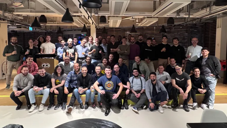Group photo of the Coding Bunker community in a coworking space, with Ludovico Besana among the smiling participants.
