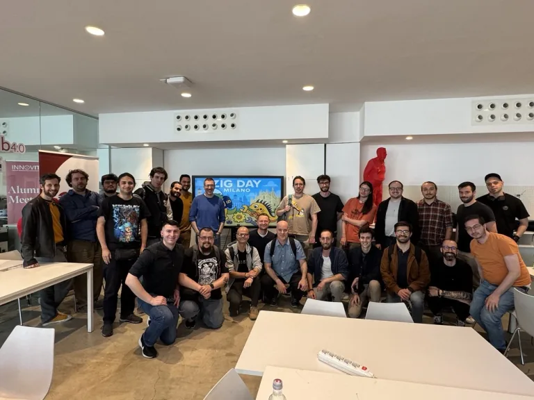 Group photo of participants at Zig Day in a bright event space, with Ludovico Besana among them.